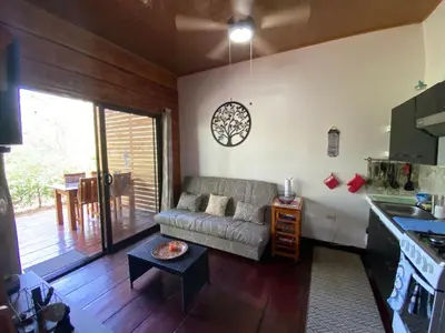a living room with a couch and a kitchen at Casa Natural Madera in Brasilito