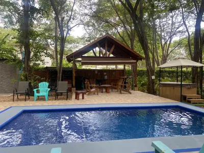 a swimming pool with a gazebo and a house at Casa Natural Madera in Brasilito