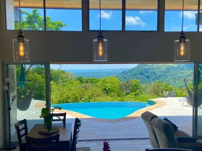 a room with a view of a pool through a window at Casa de Teak in Savegre
