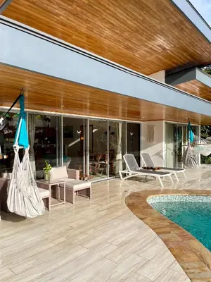 a living room with a pool and a house at Casa de Teak in Savegre