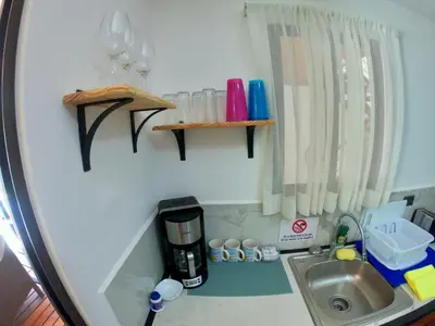 a small kitchen with a sink and a coffee maker at Shark Town Mal Pais in Santa Teresa Beach