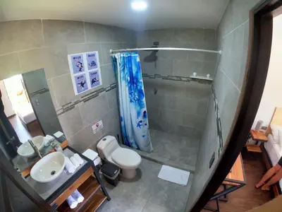 a bathroom with a shower and a toilet and a sink at Shark Town Mal Pais in Santa Teresa Beach