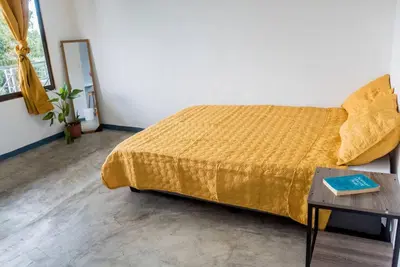 a bedroom with a yellow bed and a table at NAPPO Room 2 Alajuela, Heredia,SJO,5min from airport NO PARKING in Guácima