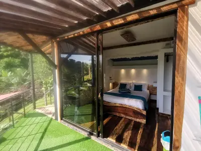 a room with a bed and a balcony at Glamping Tomaselli in Manuel Antonio