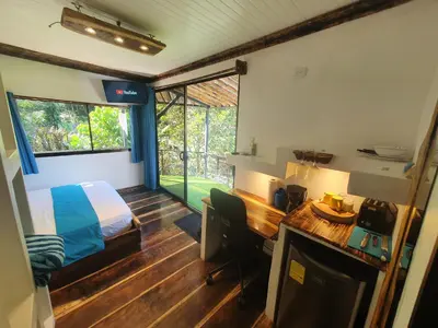 a bedroom with a bed and a desk with a desk at Glamping Tomaselli in Manuel Antonio