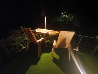 a wooden table and two chairs in the dark at Glamping Tomaselli in Manuel Antonio