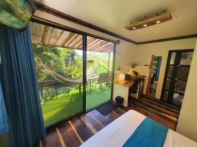a room with a large window and a hammock at Glamping Tomaselli in Manuel Antonio