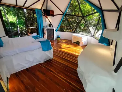 a room with two beds in a tent with windows at Glamping Tomaselli in Manuel Antonio