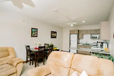 a living room with a couch and a kitchen at Apartamento Ganesha Liberia in Santa Ana