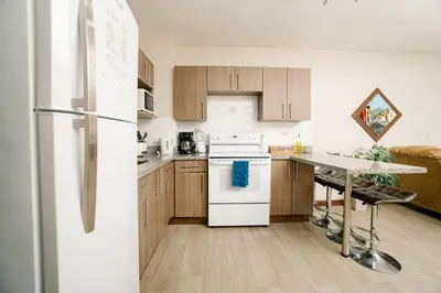 a kitchen with a white refrigerator and a table at Apartamento Ganesha Liberia in Santa Ana