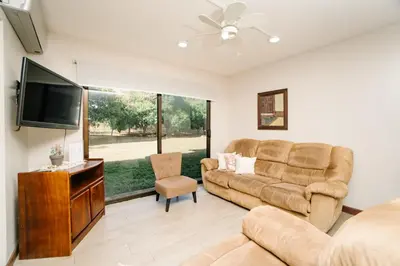 a living room with a couch and a flat screen tv at Apartamento Ganesha Liberia in Santa Ana