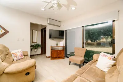 a living room with two couches and a tv at Apartamento Ganesha Liberia in Santa Ana