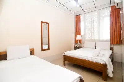 a hotel room with two beds and a mirror at Hotel Aldea Chorotega Puntarenas in Puntarenas