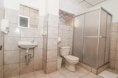 a bathroom with a shower and a toilet and a sink at Hotel Aldea Chorotega Puntarenas in Puntarenas