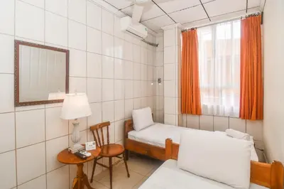 a small room with a bed and a table at Hotel Aldea Chorotega Puntarenas in Puntarenas