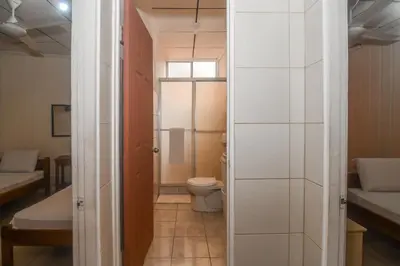 a small bathroom with a toilet and a shower at Hotel Aldea Chorotega Puntarenas in Puntarenas