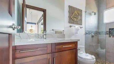 a bathroom with a sink and a toilet and a mirror at Stunning Mountaintop Property with Stylish Main Home, Private Guesthouse & Infinity Pool in Santa Cruz