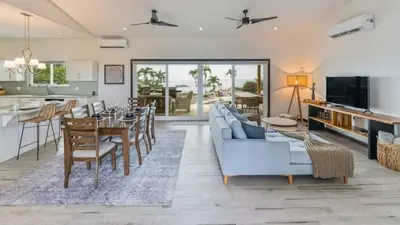 a living room with a couch and a table and a kitchen at Stunning Mountaintop Property with Stylish Main Home, Private Guesthouse & Infinity Pool in Santa Cruz