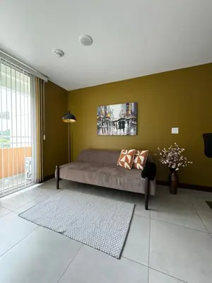 a bedroom with a bed and a green wall at Lovely Apartment near Costa Rica airport in Heredia