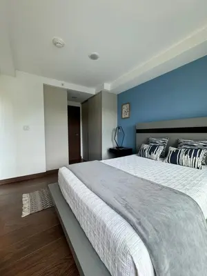 a bedroom with a large bed with a blue wall at Lovely Apartment near Costa Rica airport in Heredia