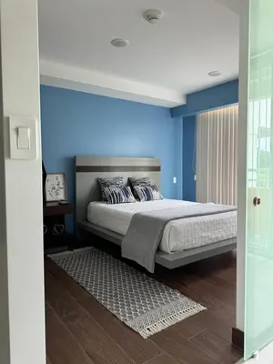 a bedroom with blue walls and a large bed at Lovely Apartment near Costa Rica airport in Heredia