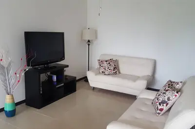a living room with a couch and a tv at Oceanview 6th Floor Jaco Condo in Jacó