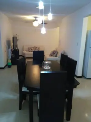 a dining room with a table and chairs and a couch at Oceanview 6th Floor Jaco Condo in Jacó