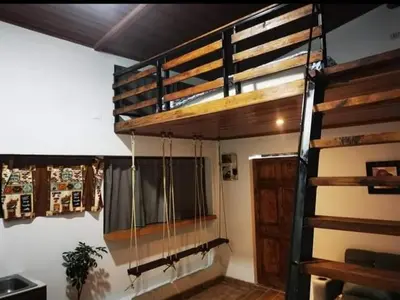 a loft bed in a room with a window at Cabaña Bambú in Cartago