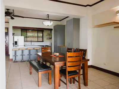 a kitchen and dining room with a wooden table and chairs at Presidential Suites 4 - Spacious condo in the heart of Flamingo, sleeps 6 in Playa Flamingo