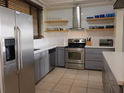 a kitchen with stainless steel appliances and white cabinets at Presidential Suites 4 - Spacious condo in the heart of Flamingo, sleeps 6 in Playa Flamingo
