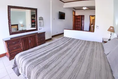 a bedroom with a large bed and a large mirror at Presidential Suites 4 - Spacious condo in the heart of Flamingo, sleeps 6 in Playa Flamingo
