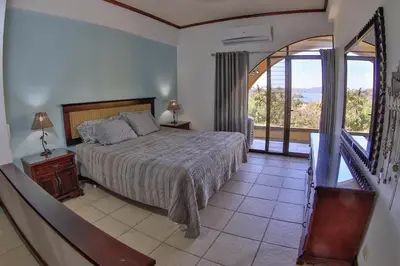 a bedroom with a bed and a balcony at Presidential Suites 4 - Spacious condo in the heart of Flamingo, sleeps 6 in Playa Flamingo