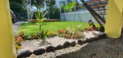 a garden with flowers and rocks in a yard at Tío King Hospedaje Turístico in Uvita
