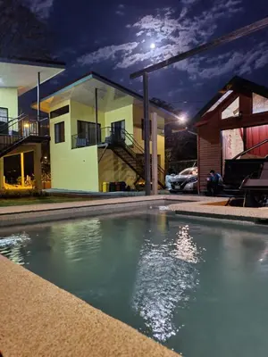a swimming pool in front of a house at night at Tío King Hospedaje Turístico in Uvita