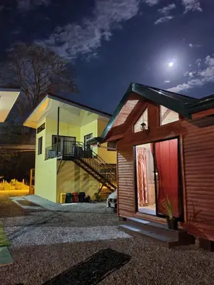 a house at night with the moon in the sky at Tío King Hospedaje Turístico in Uvita