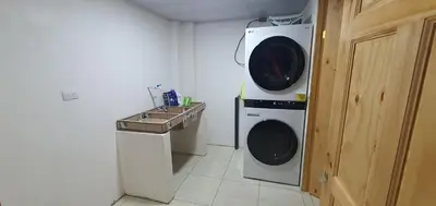 a washer and dryer in a small room at Tío King Hospedaje Turístico in Uvita
