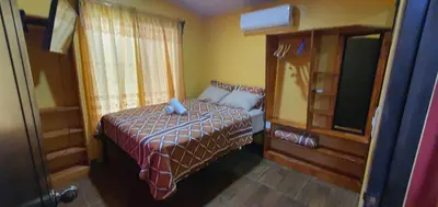 a small bedroom with a bed and a window at Tío King Hospedaje Turístico in Uvita