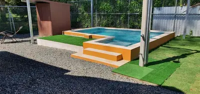 a swimming pool with steps leading into a yard at Tío King Hospedaje Turístico in Uvita