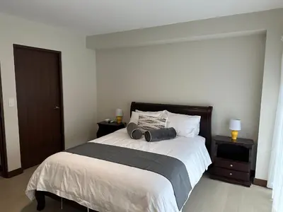 a bedroom with a large bed with two night stands at Nuevo y espectacular APT - 100 MBPS 15 min del aeropuerto in San José