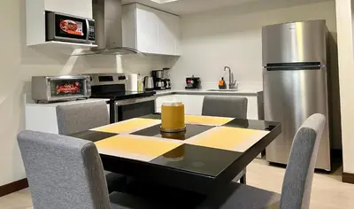 a kitchen with a table with chairs and a refrigerator at Nuevo y espectacular APT - 100 MBPS 15 min del aeropuerto in San José