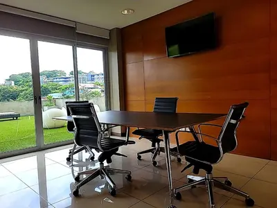 a conference room with a table and chairs and a television at Nuevo y espectacular APT - 100 MBPS 15 min del aeropuerto in San José