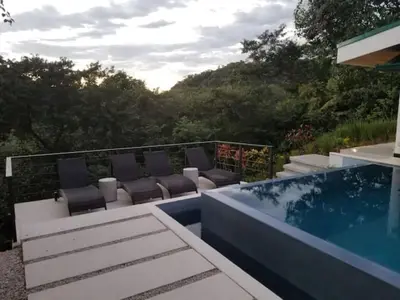 a patio with chairs and a swimming pool at New Hill top Home with a Beautiful Tropical View in Esperanza