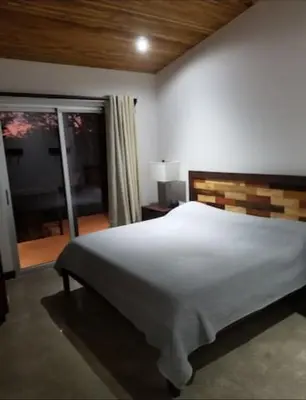 a bedroom with a large white bed and a window at New Hill top Home with a Beautiful Tropical View in Esperanza