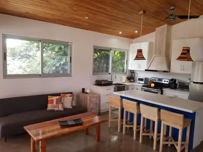 a kitchen and living room with a couch and a table at New Hill top Home with a Beautiful Tropical View in Esperanza