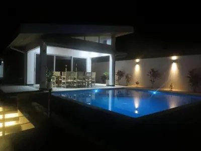 a large swimming pool in a house at night at New Hill top Home with a Beautiful Tropical View in Esperanza