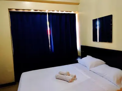 a teddy bear laying on a bed in front of a window at Hotel Alajuela Costa Rica Airport in Alajuela City