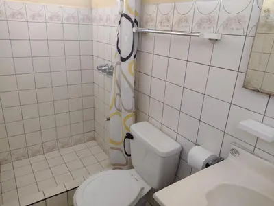 a small bathroom with a toilet and a sink at Hotel Alajuela Costa Rica Airport in Alajuela City