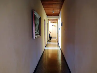 a hallway with a long corridor with a painting on the wall at Hotel Alajuela Costa Rica Airport in Alajuela City