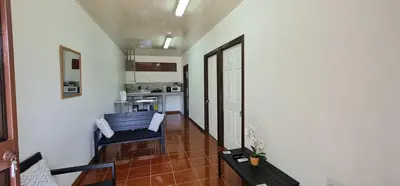 a living room with two chairs and a kitchen at Sleep&Go! Apartamento 2 habitaciones 4 personas Siquirres centro in Siquirres