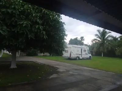 a white rv parked in a yard with a tree at Sleep&Go! Apartamento 2 habitaciones 4 personas Siquirres centro in Siquirres